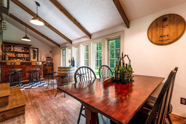 dining space featuring dark hardwood / wood-style flooring, lofted ceiling with beams, and indoor bar