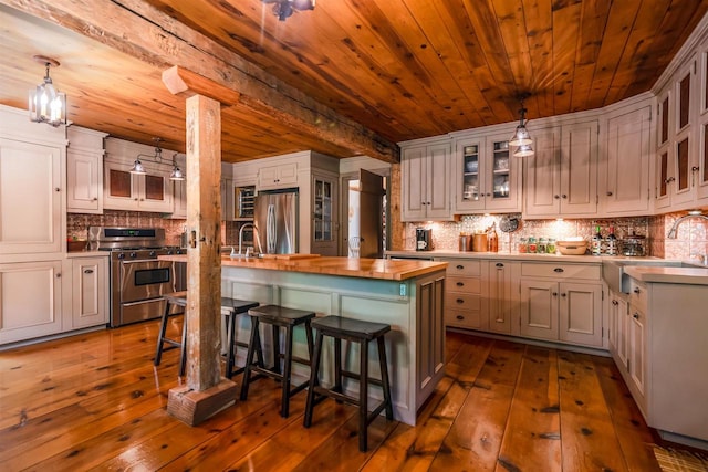 kitchen with decorative light fixtures, dark hardwood / wood-style floors, and an island with sink