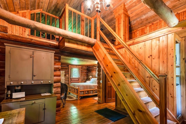 interior space with an inviting chandelier, light wood-type flooring, high vaulted ceiling, wood ceiling, and rustic walls