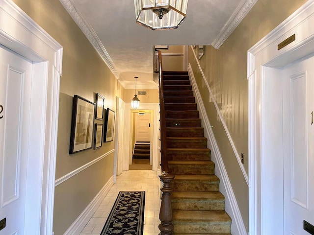 stairway featuring crown molding and light tile floors