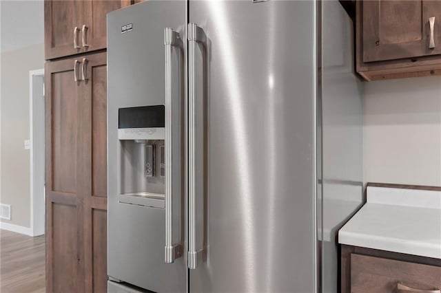 kitchen with stainless steel fridge with ice dispenser and light wood-type flooring