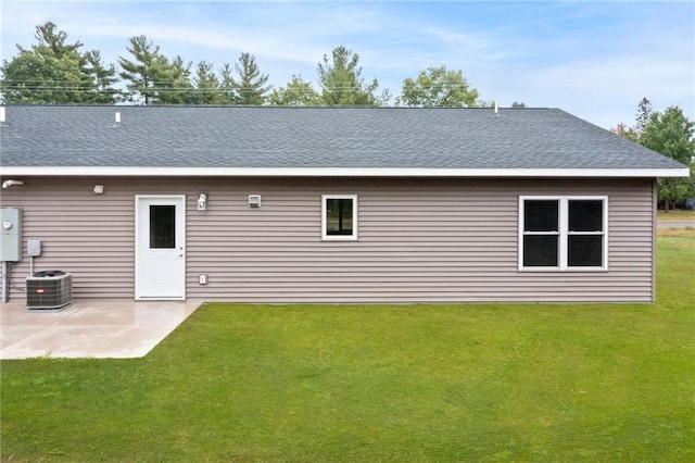 rear view of property with central air condition unit, a yard, and a patio area