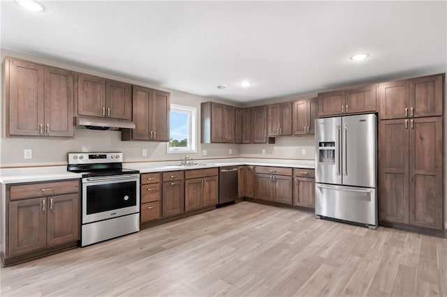 kitchen with light wood-type flooring, sink, and stainless steel appliances