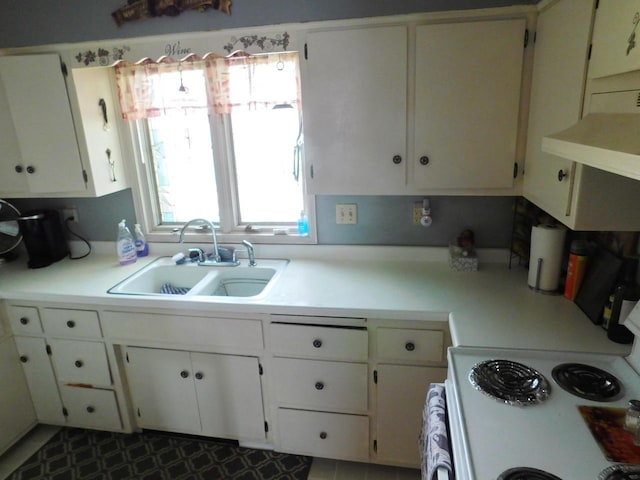 kitchen with stove, white cabinets, sink, and tile flooring