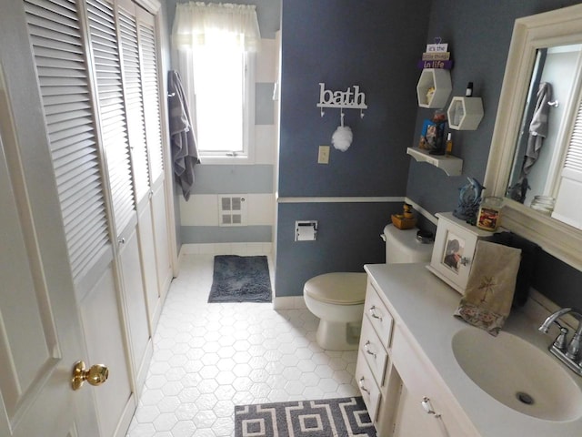 bathroom with toilet, tile floors, and large vanity