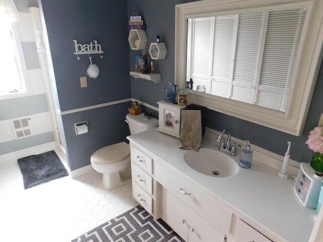 bathroom featuring toilet, vanity with extensive cabinet space, and tile flooring