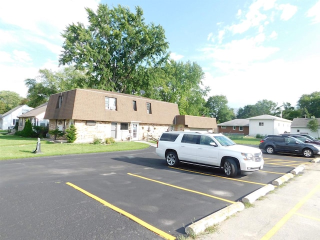 view of parking / parking lot featuring a yard