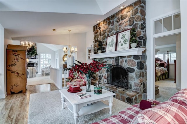 carpeted living room featuring a notable chandelier, a fireplace, and lofted ceiling