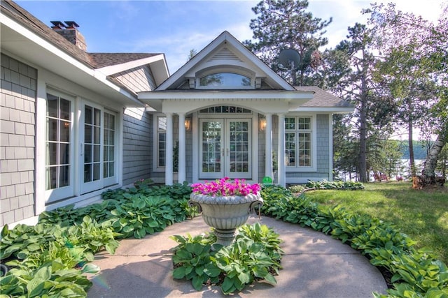 entrance to property featuring a lawn and french doors