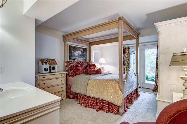 carpeted bedroom with connected bathroom, access to exterior, and sink