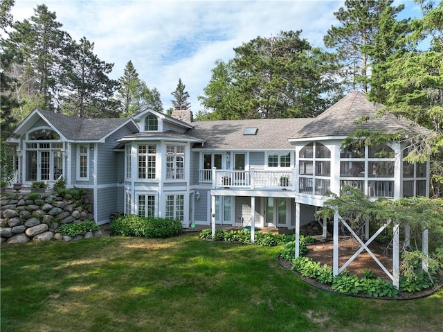 back of house featuring a balcony and a lawn