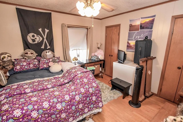 bedroom with a textured ceiling, light hardwood / wood-style floors, and ceiling fan