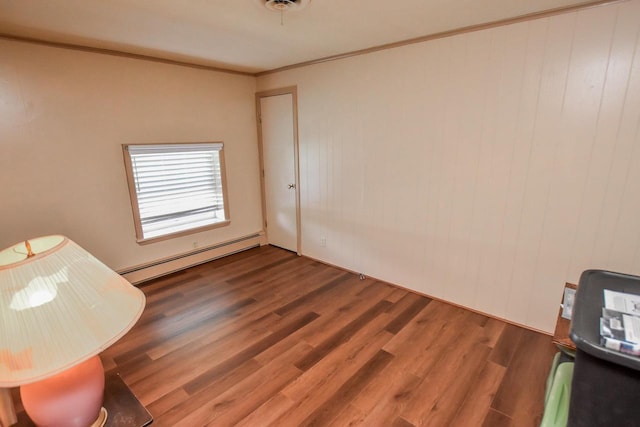 bedroom with dark hardwood / wood-style flooring, a baseboard heating unit, and crown molding