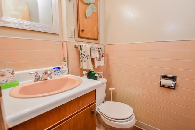 bathroom featuring tile walls, oversized vanity, and toilet