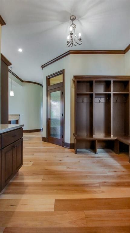 interior space featuring ornamental molding, light hardwood / wood-style floors, and a notable chandelier