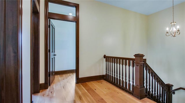 stairs with a notable chandelier and light wood-type flooring