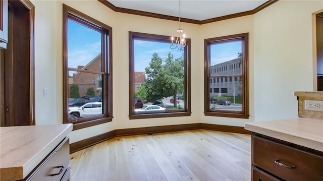 unfurnished dining area with a chandelier, a wealth of natural light, and light hardwood / wood-style flooring