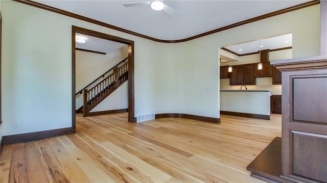 unfurnished living room with crown molding, ceiling fan, light wood-type flooring, and sink