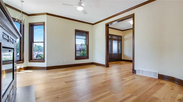 unfurnished room with ornamental molding, light wood-type flooring, and ceiling fan with notable chandelier