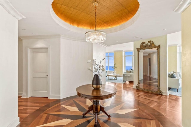 corridor with a notable chandelier, a raised ceiling, and dark parquet floors