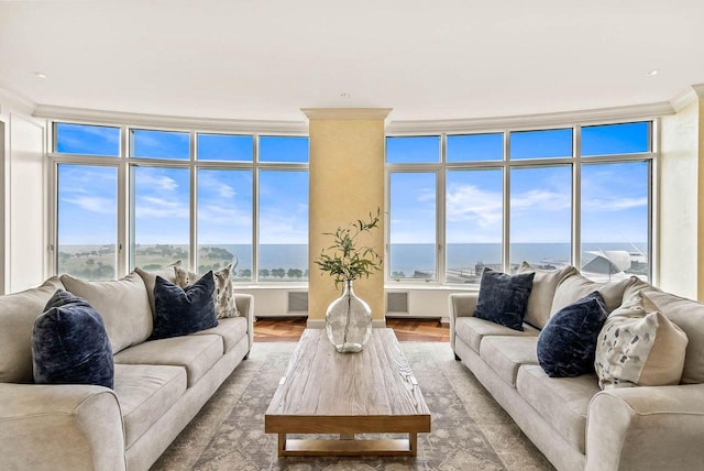 living room featuring plenty of natural light, a water view, a wall of windows, and light wood-type flooring