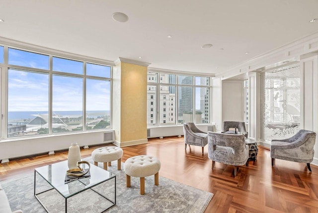 living area with crown molding and light parquet floors