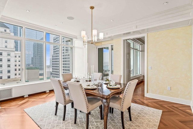 dining room with a notable chandelier, dark parquet floors, and ornamental molding