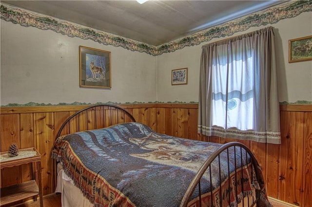 bedroom featuring wood walls