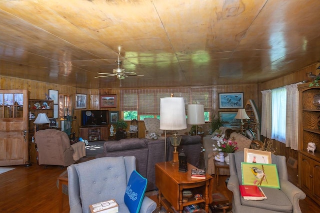 living room with wood walls, plenty of natural light, dark hardwood / wood-style floors, and ceiling fan