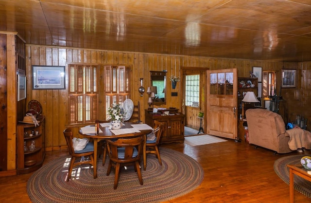 dining room with wooden walls and dark hardwood / wood-style flooring