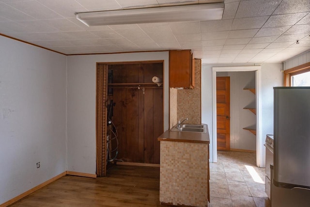 kitchen featuring stainless steel refrigerator, tile flooring, and sink