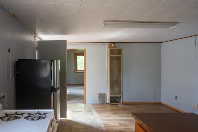 kitchen featuring black refrigerator and light tile floors