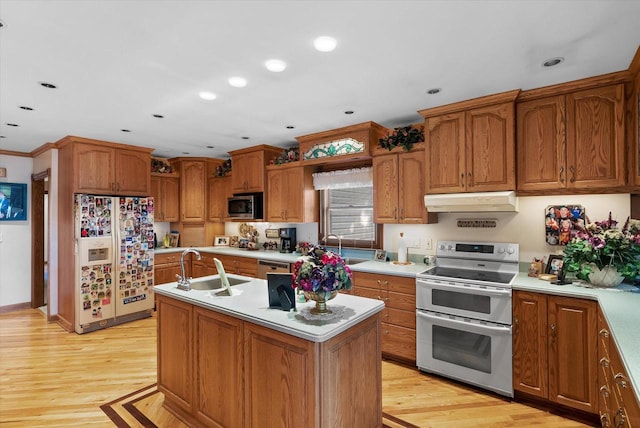 kitchen featuring appliances with stainless steel finishes, light wood-type flooring, sink, a kitchen island with sink, and range hood