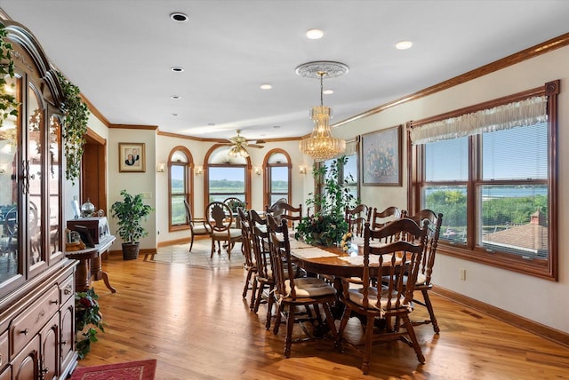 dining area featuring ceiling fan with notable chandelier, a healthy amount of sunlight, and light hardwood / wood-style floors