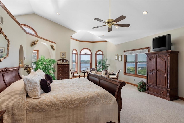 bedroom featuring lofted ceiling, multiple windows, ceiling fan, and light colored carpet