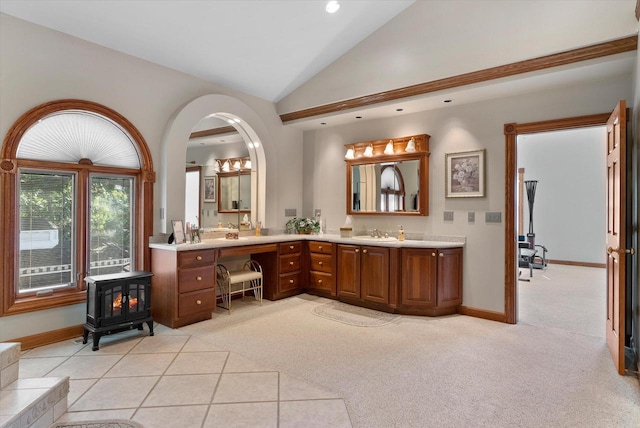 bathroom featuring vanity, a wood stove, and lofted ceiling