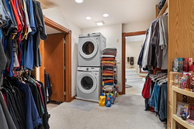 laundry area featuring light tile floors and stacked washer and dryer