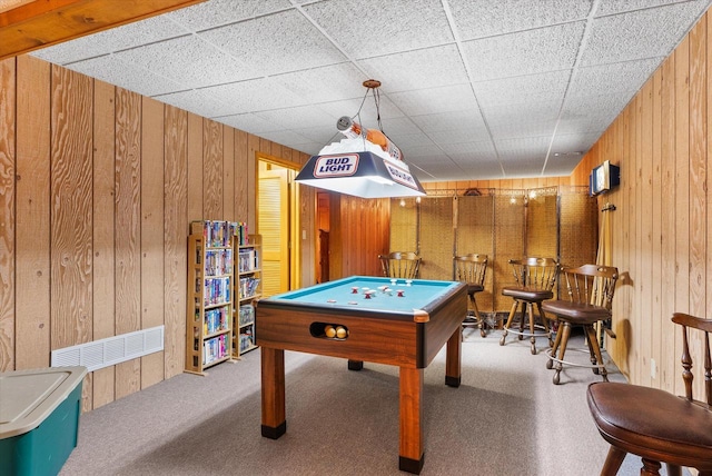 rec room with a drop ceiling, wooden walls, billiards, light carpet, and bar