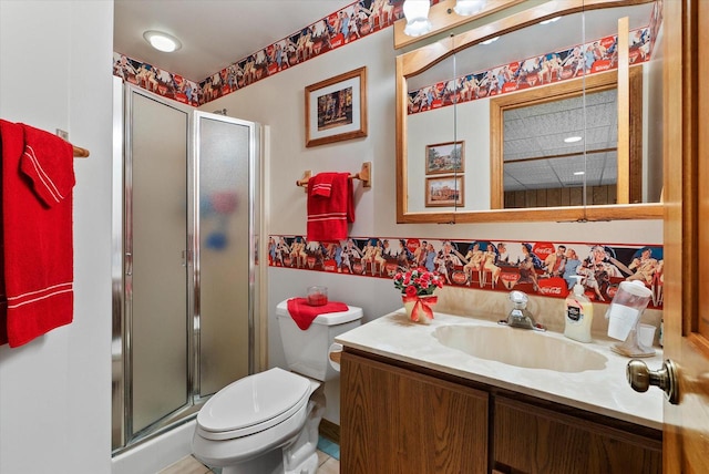 bathroom featuring toilet, vanity, and a shower with shower door