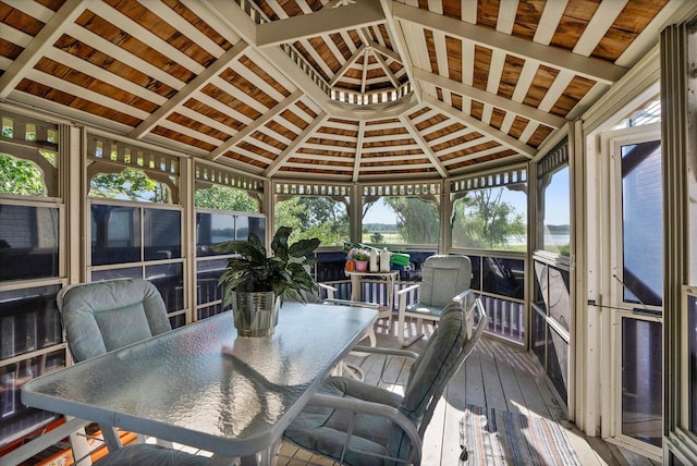 sunroom with a healthy amount of sunlight and vaulted ceiling