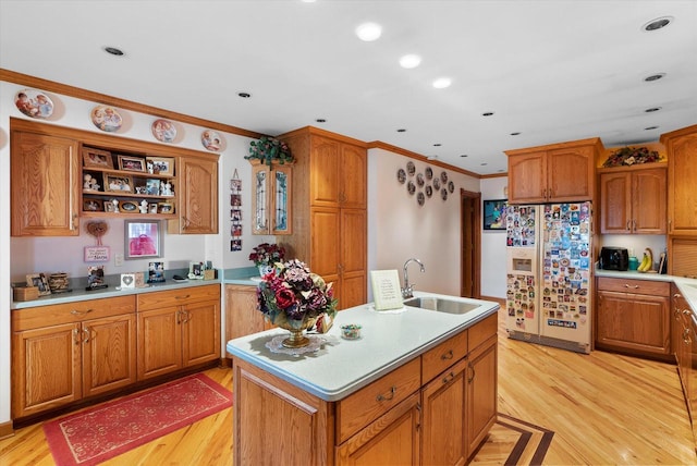 kitchen with white fridge with ice dispenser, a center island with sink, sink, and light hardwood / wood-style flooring