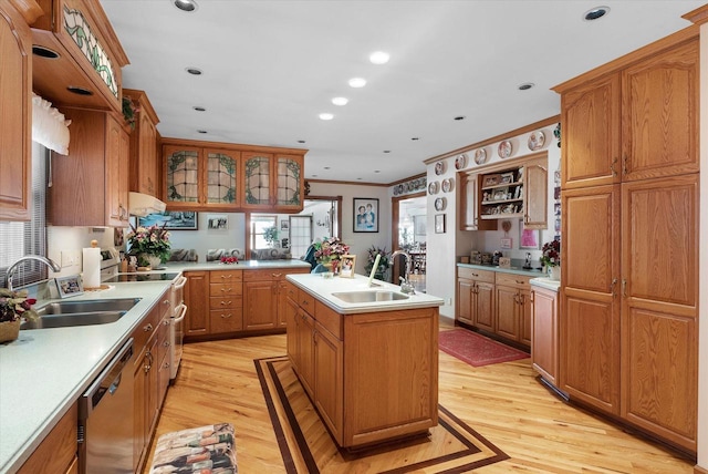 kitchen with light hardwood / wood-style floors, sink, a center island with sink, stainless steel dishwasher, and range with two ovens