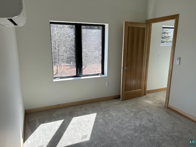 unfurnished room with a wall unit AC and carpet floors