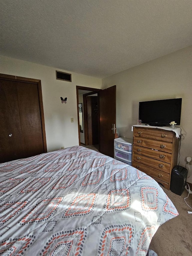 bedroom with a textured ceiling and carpet floors