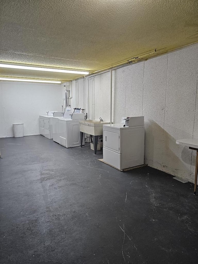 basement with a textured ceiling and independent washer and dryer