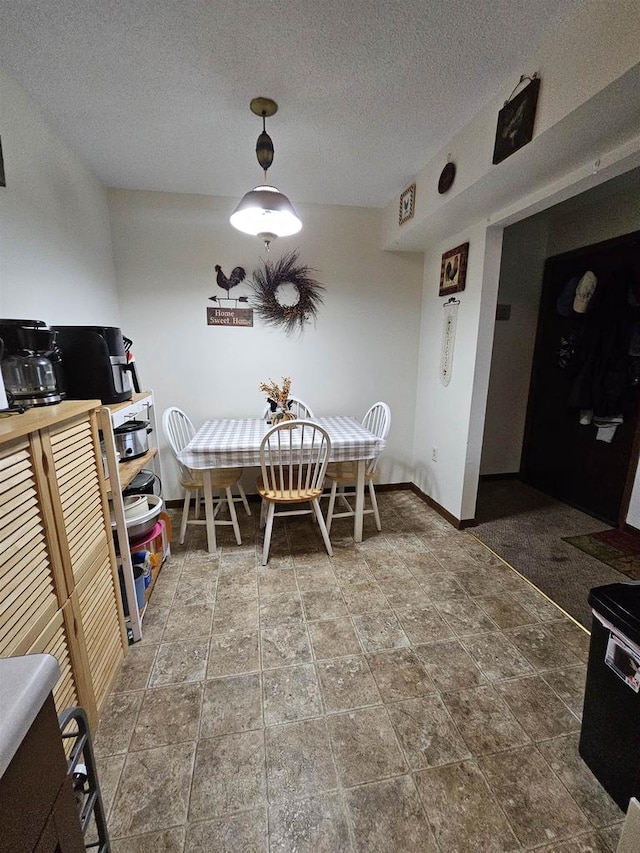 dining room featuring tile flooring and a textured ceiling