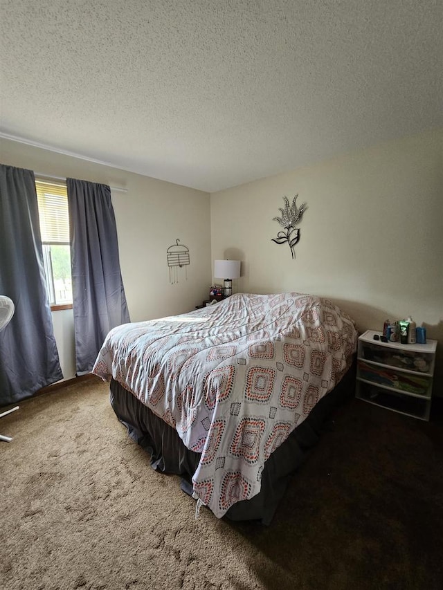 bedroom featuring dark colored carpet and a textured ceiling