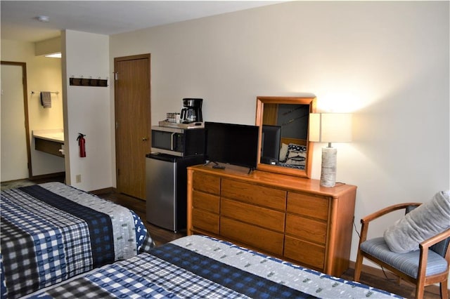 bedroom featuring refrigerator and dark hardwood / wood-style floors