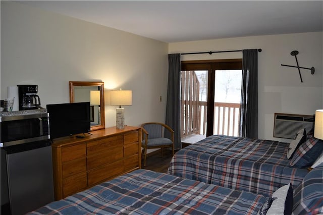 bedroom featuring refrigerator, access to exterior, and a wall unit AC