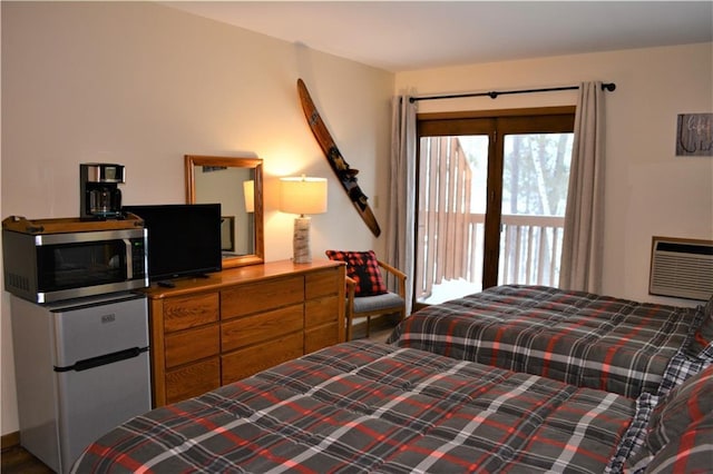 bedroom featuring a wall mounted air conditioner and white fridge